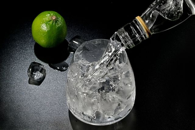 グラスにお酒を注ぐ様子とライム