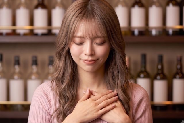 胸に手を当てて微笑む女性