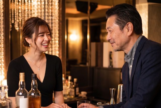笑顔で会話する女性とスーツの男性