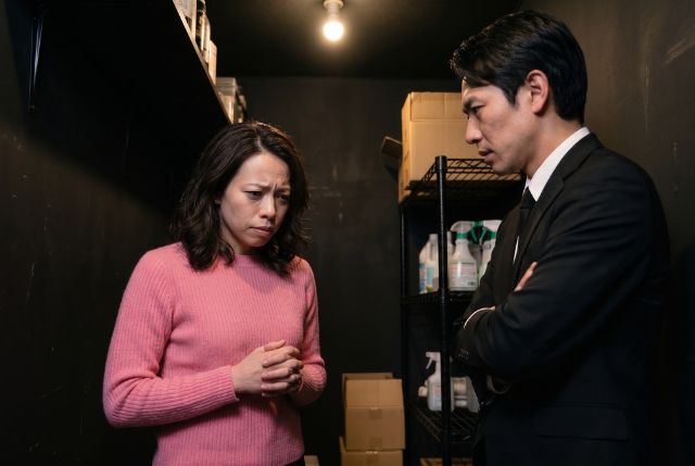 黒いスーツの男性とピンクのトップスの女性