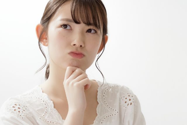 顎に手を当てて困った表情の女性