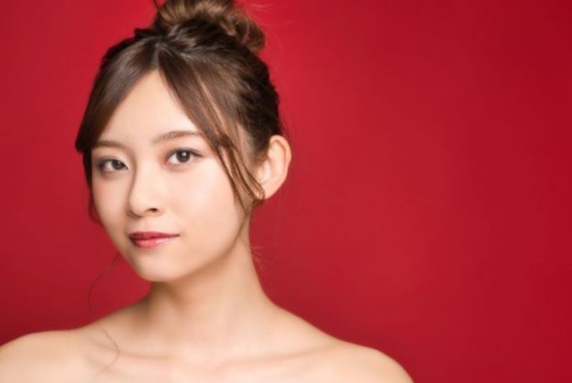 赤い壁の前に若い女性