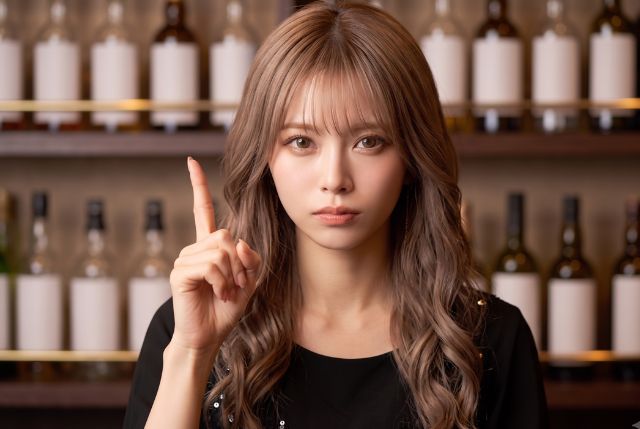人差し指を立てる真剣な表情の女性
