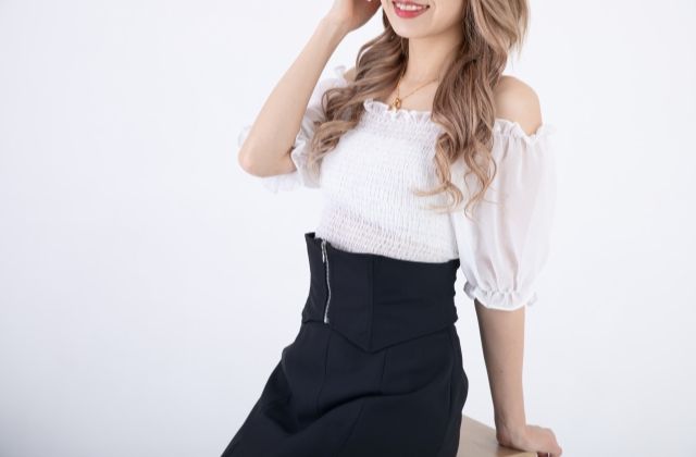 笑顔で髪をかき上げるドレスの女性