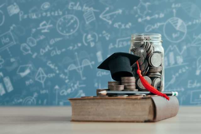 学費を表現したお金と辞書の画像