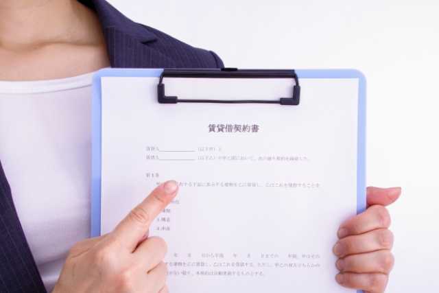 賃貸貸契約書を持つ不動産会社の女性