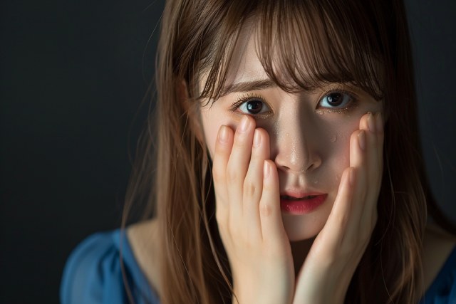 頬に手をあてて悲しそうな表情の女性