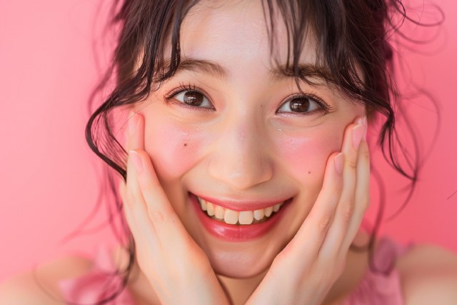頬に手をあてて笑顔の女性