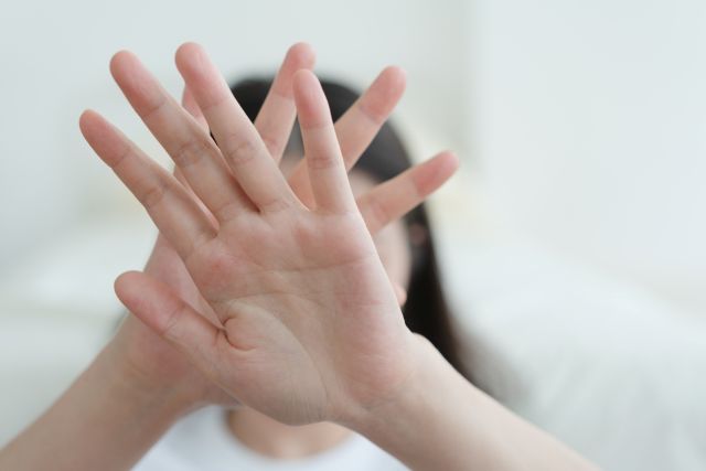 手で拒否している女性