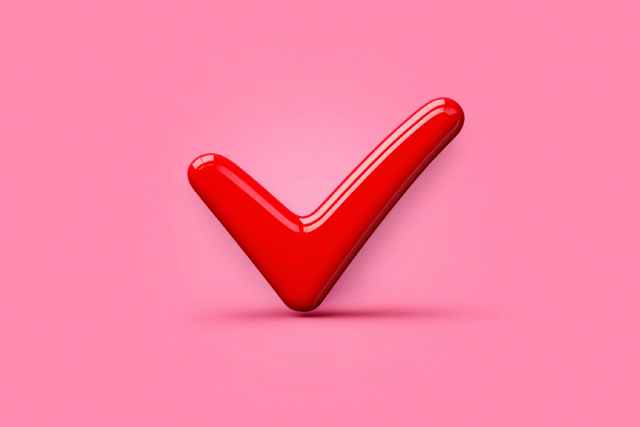 ピンクの背景にある赤いチェックマーク
