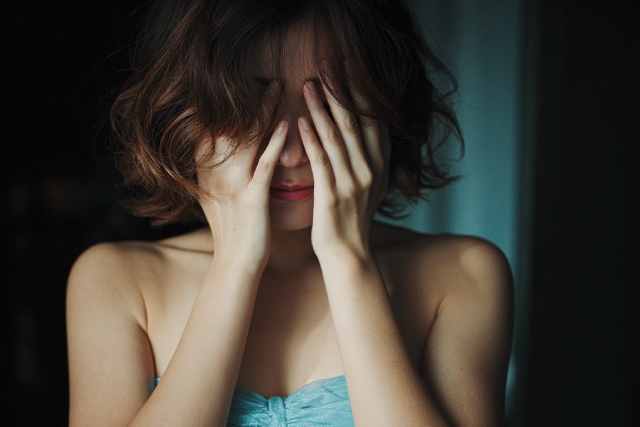 顔を覆って悲しんでいる女性