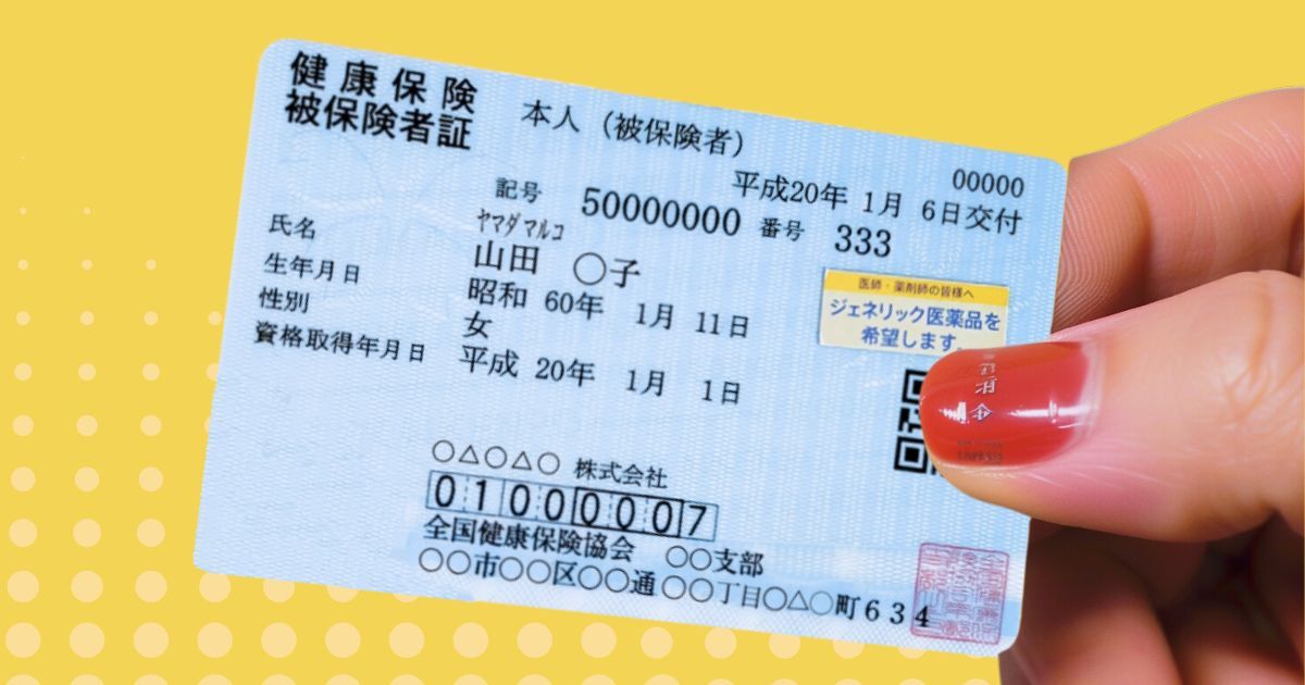 保険証を手に持つ女性の手