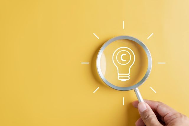 黄色の背景の前にある電球マークと虫眼鏡
