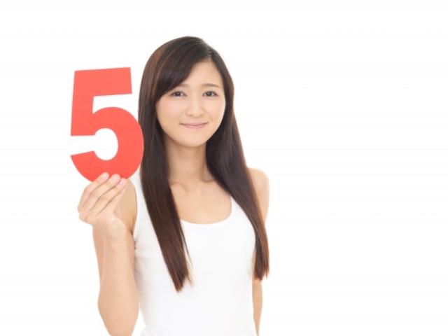 数字の「5」を持つ若い日本人女性
