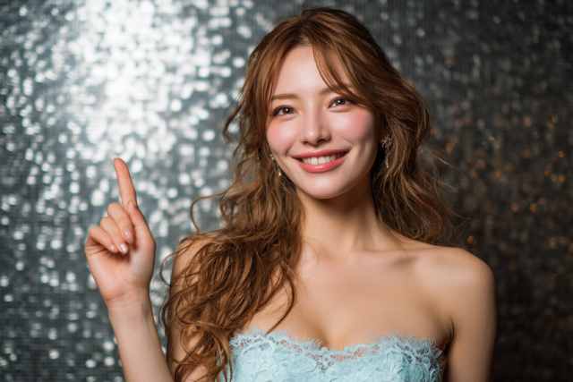 指さしをしている水色のドレスの女性