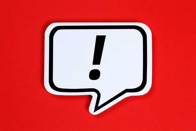 赤い背景にある白い吹き出しとビックリマーク