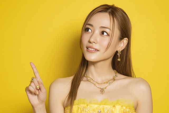 上を指さす黄色いドレスの女性