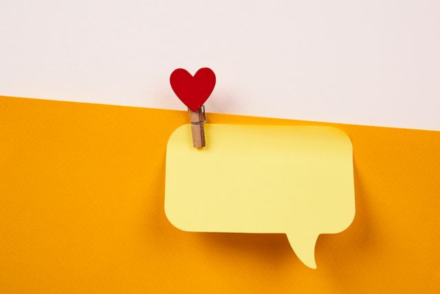 黄色の吹き出しの付箋を止めるハートマークのクリップ