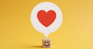 ハートの吹き出しを浮かべるニコニコマーク