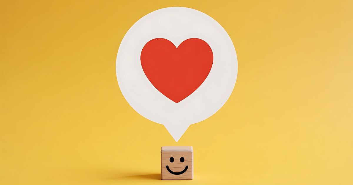 ハートの吹き出しを浮かべるニコニコマーク