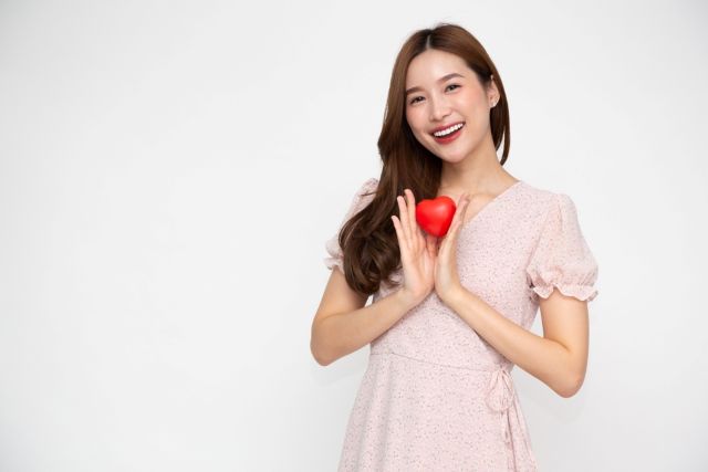 手にハートを持つ女性
