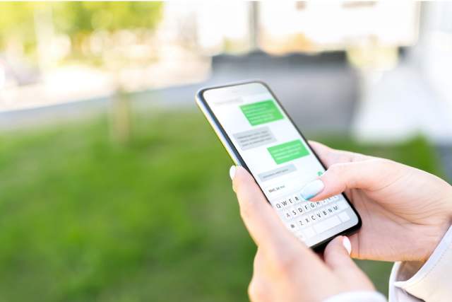 スマホでメッセージを送っている手元