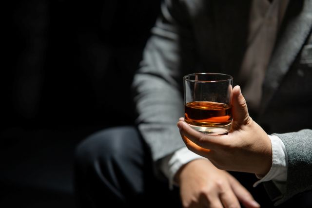 ウイスキーグラスを持つ男性
