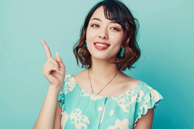 緑色のドレスを着た黒い短い髪の女性