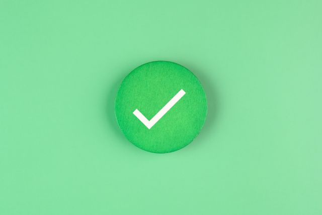 緑の背景の前にある緑のチェックマーク