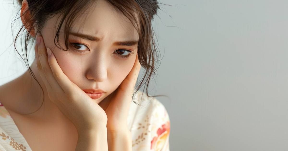 悩ましい表情を浮かべる日本人の若い女性