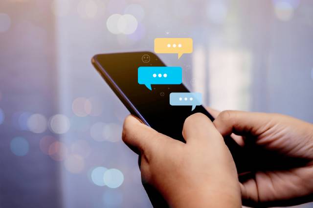 スマホを持った男性がメッセージを返している様子