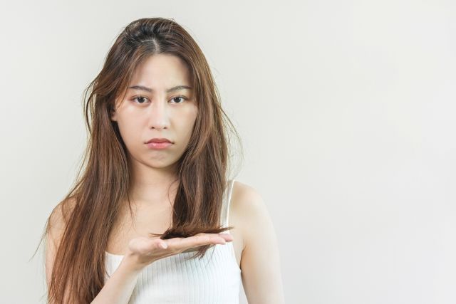 横を手のひらで示す女性