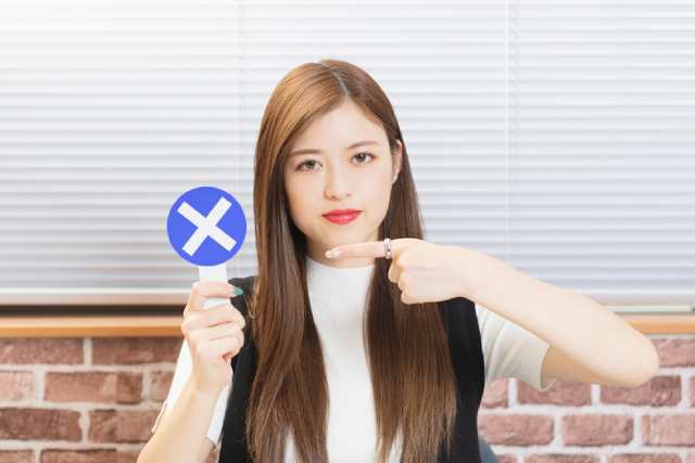 罰マークのプラカードを持つ茶髪の女性