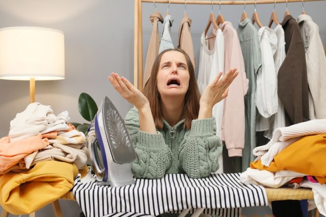 アイロンをかけながら上を向いて泣いている女性