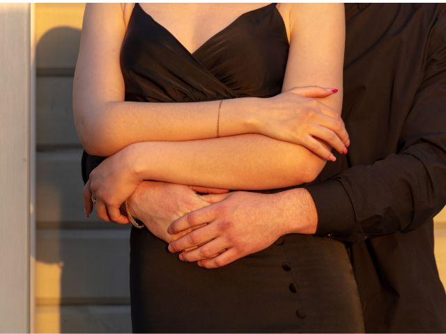 後ろから女性を抱く男性と黒いドレスの女性