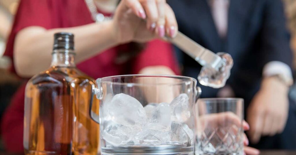 グラスに氷を入れる女性