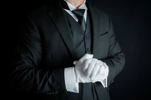 手を合わせるスーツのウエイター