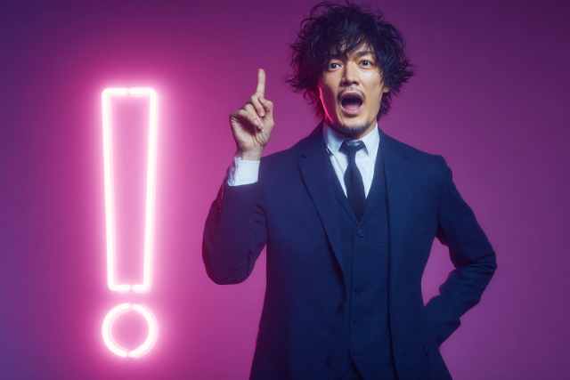 ピンクのビックリマークとスーツの男性