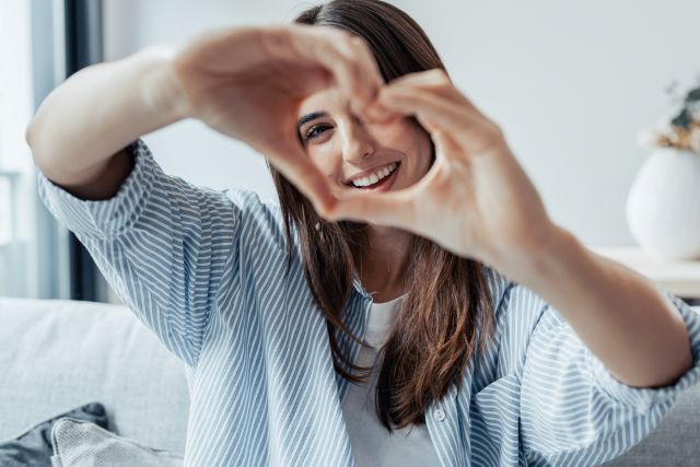 手でハートマークを作っている女性