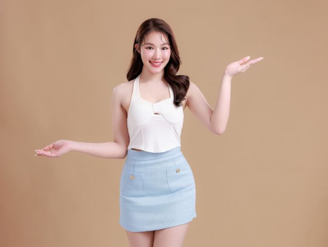 両手で何かを指しているドレスの女性