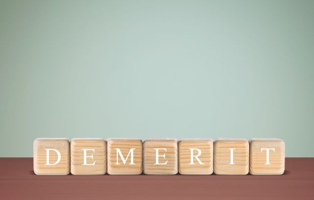 DEMERITと書かれた木のブロック