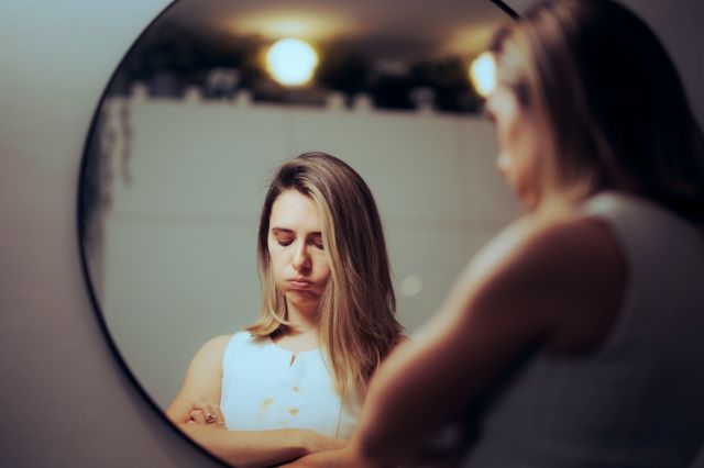鏡を見て落ち込む女性