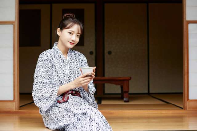 浴衣を着て旅館で涼む若い日本人女性