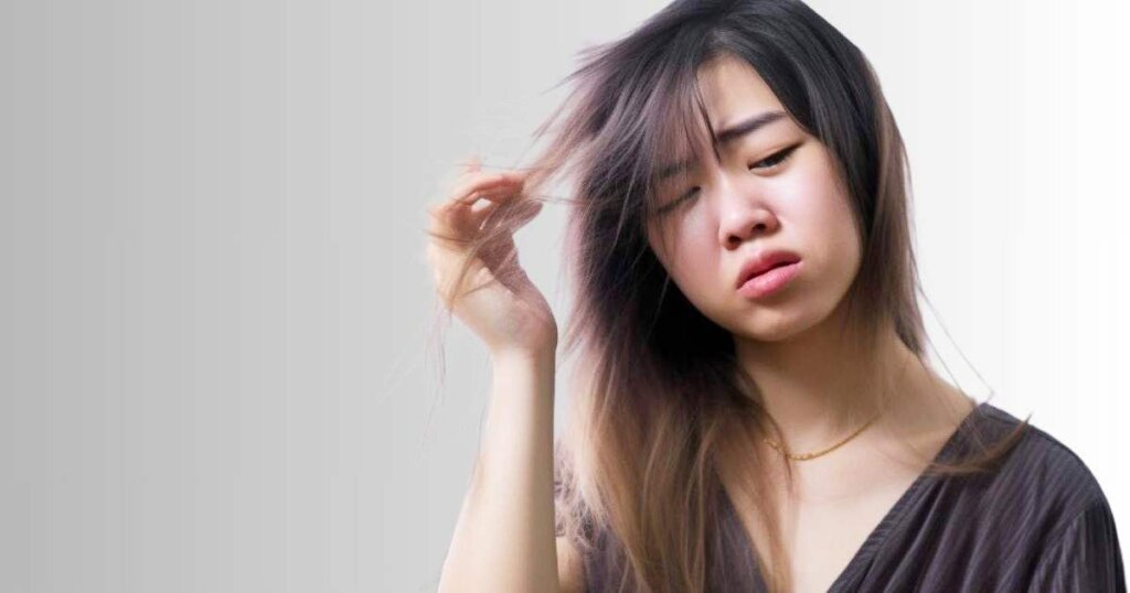 不機嫌な表情の髪の毛が痛んでいる女性