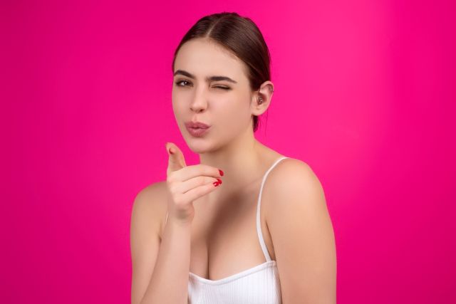 こちらに向かって指さす女性