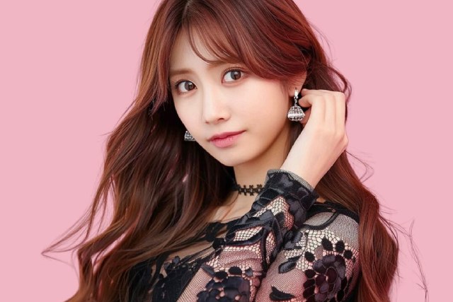 髪を耳にかける黒いドレスを着た女性