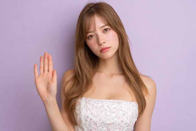 手を挙げているドレス姿の女性