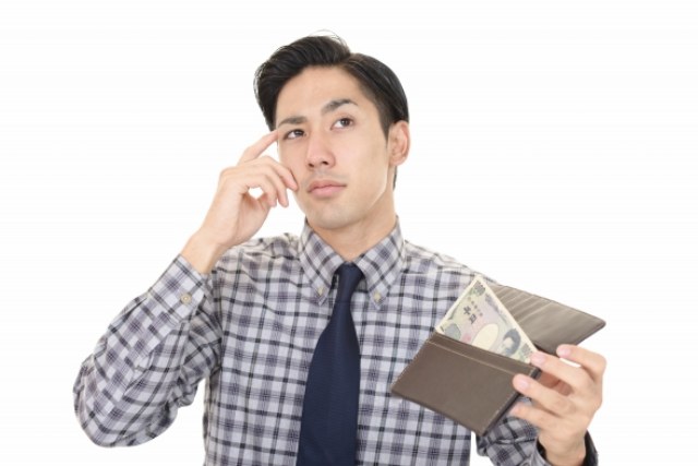 お財布を持ちながら考える男性