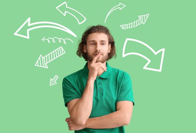 色々な方向に行く矢印を浮かべて悩む男性