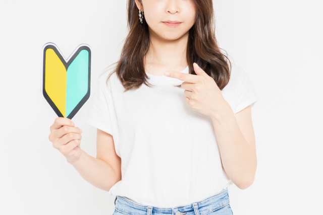 初心者マークを手にもち指指す女性